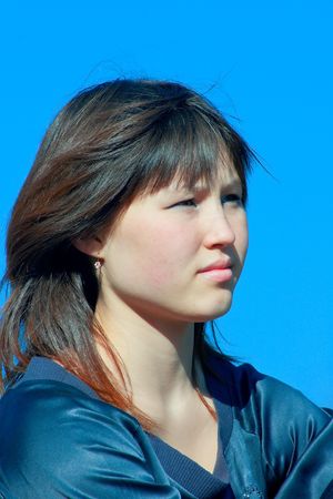 Portrait of the beautiful asian girl against blue skyの写真素材