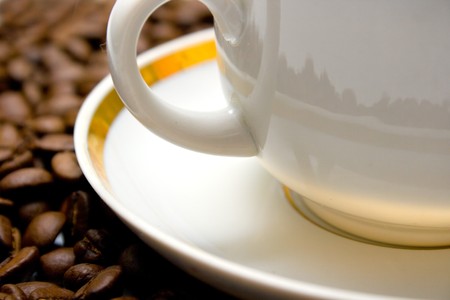Cup with hot coffee on a coffee beans background