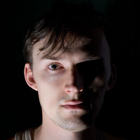 Portrait of the gloomy caucasian men on the black backgroundの写真素材