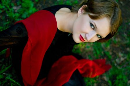 The young women with red scarf against the green grass