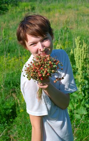 Beautiful young girl with aromatic wild strawberryの写真素材