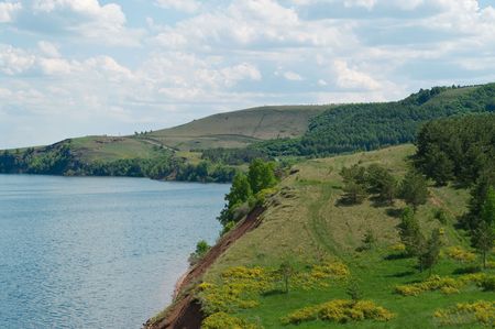 Summer landscape with the cloudy sky. Hills of the Ural mountains and blue lakeの写真素材