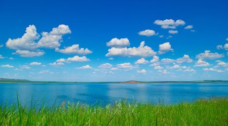 Summer landscape with quiet water of lake and cloudy skyの写真素材