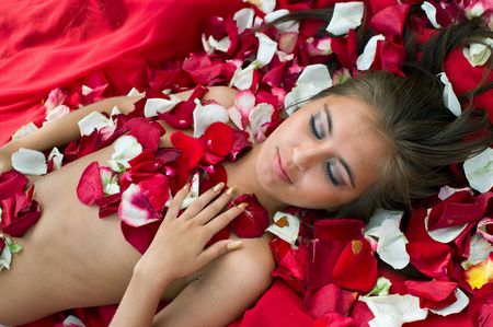 Beautiful sleeping girl in rose petal. Spa resortの写真素材