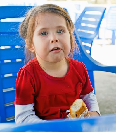 Portrait of the little girl with pie in cafe の写真素材