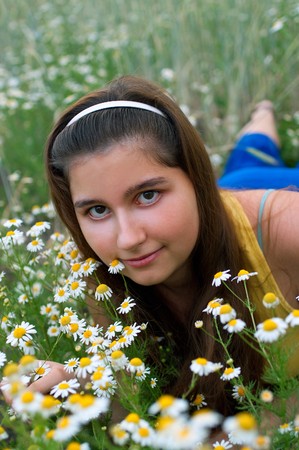 Young girl on chamomiles field. Shallow DOFの写真素材