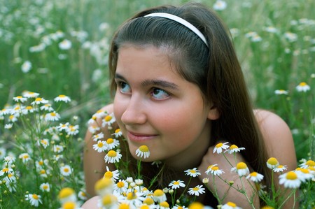Young girl on chamomiles field. Shallow DOFの写真素材