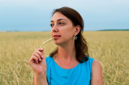 Beautiful girl in blue dress in field. Shallow DOF 