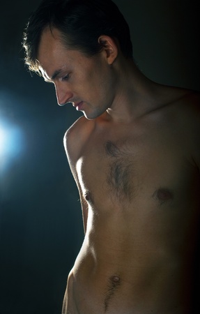 Portrait of the young naked men on dark backgroundの写真素材