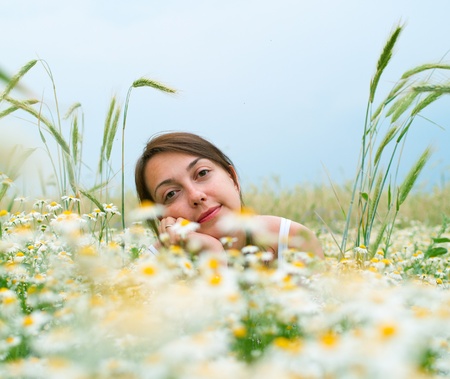 Young women on chamomiles field. Shallow DOF の写真素材