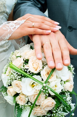Hands of a newly-married couple on flower bouquet の写真素材