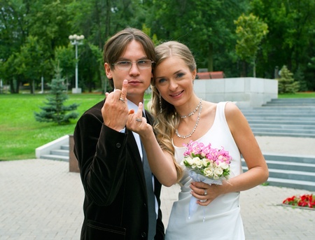 Smilind bride and groom against summer landscape の写真素材