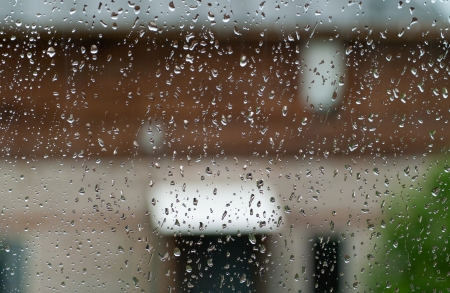Drops on glass from an evening rain against backgground with rural house. Shallow DOF の写真素材