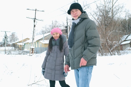Happy smiling young couple against winter landscapeの写真素材