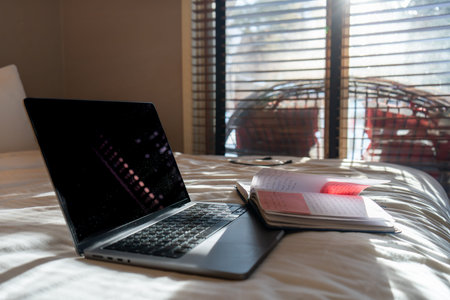 Laptop and Notebook on Bed in Sunlight for Remote Work, Study, or Relaxation. Productive Morning...