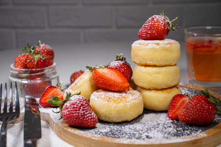 Cheese pancakes, homemade traditional Ukrainian and Russian syrniki with strawberries on wooden background.の写真素材