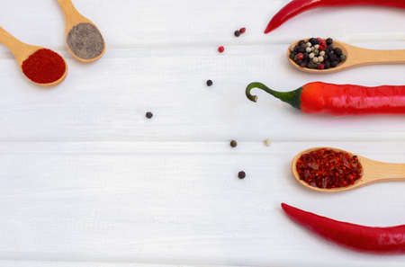 Red hot chili pepper and mix of pepper on a white wooden backgroundの写真素材