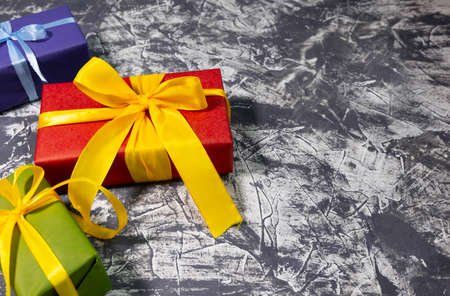 Gift box Trendy styled photo Three stylish multicolored gift boxes with bright ribbons on white...
