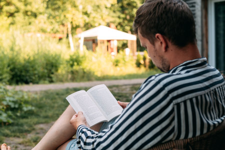 Young man read book sitting on nature.の写真素材