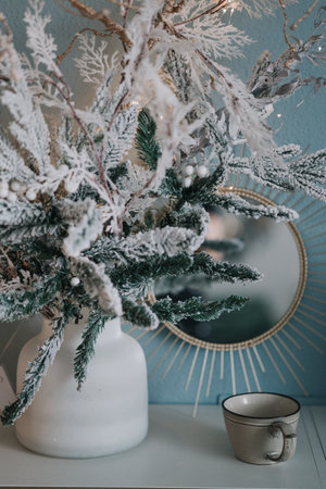 white branches of a Christmas tree with a cup on a blue backgroundの写真素材