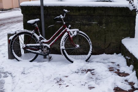 A bicycle parked on the side of a tramway. snowy weather. Bike under snowの写真素材