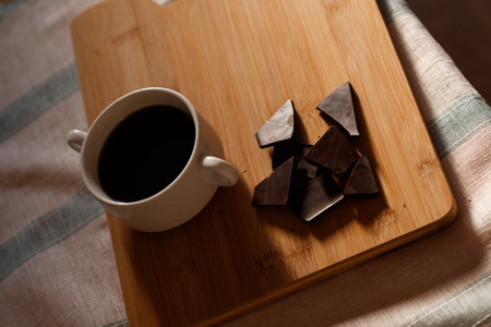 cup of coffee with dark chocolate on a wooden tray. Sweet breakfastの写真素材