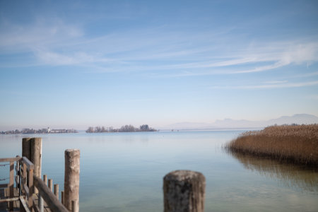 Wooden pier at Chiemsee, Bavaria, Germany. Sunny day, Bavarian Alps in the background. Lakeの写真素材