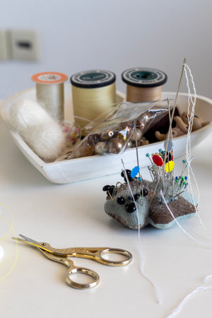 Charming hedgehog pincushion with colorful pins, essential sewing & craft supplies (thread, yarn,...