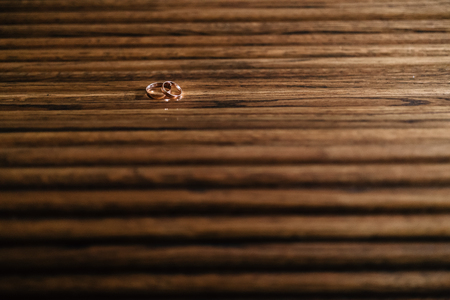 gold wedding rings on a wooden surfaceの写真素材