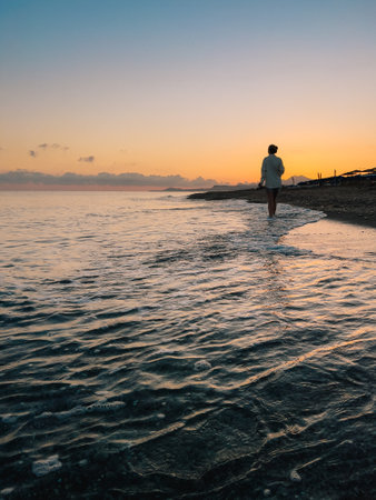 Enjoy a Serene Sunset Walk Along the Beautiful Beach, Embracing Natures Calm Beautyの写真素材