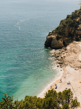 Enjoy a serene coastal view featuring crystal clear water along with a beautiful sandy beachの写真素材
