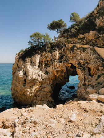 Stunning and Scenic Coastal Arch Landscape featuring Crystal Clear Blue Waters and Skiesの写真素材