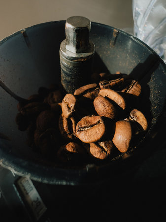 Roasted coffee beans resting inside dark grinder, waiting to be transformed into aromatic coffee powder, filling air with rich, invigorating aromas perfect for brewing. Dark grinder, coffee beansの写真素材