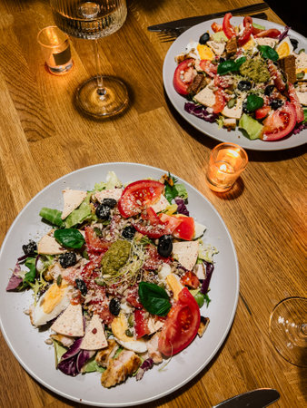 POV shot: healthy dinner with salad, eggs and greens, healthy plate glowing under soft lights, healthy food paired with wine. Wellness meal: vegetables, eggs and seeds, wellness food on stylish tableの写真素材