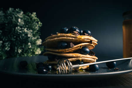 Tower of pancakes with honey, blueberries and dark chocolateの写真素材