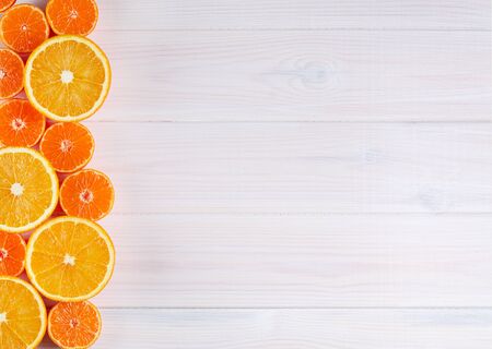 Orange citrus fruits on white wooden background