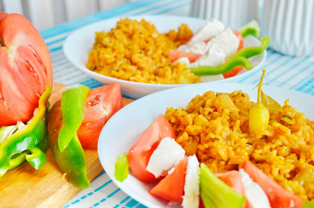 Pilaf with tomato and mozzarella on a wooden boardの写真素材