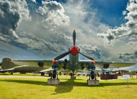 old military airplane on a background of blue sky with white clouds.の写真素材