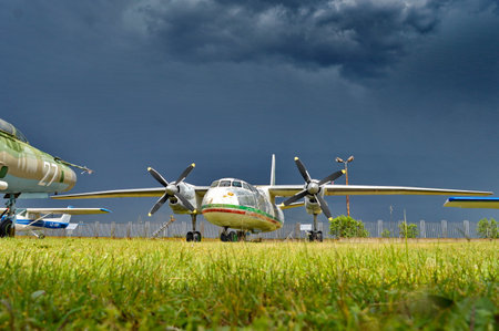 Abandoned airplane on the grass field with stormy sky.の写真素材