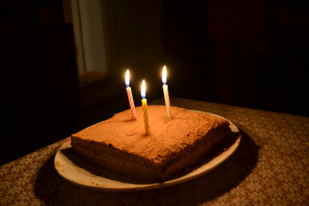 three burning candles on a birthday cake on the birthday