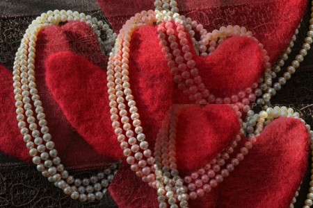 pattern of white pearls and shiny bright red fluffy felted woolの写真素材