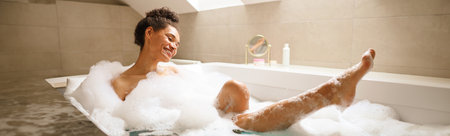 A woman smiling, bathing in a foamfilled bathtub, having funの写真素材