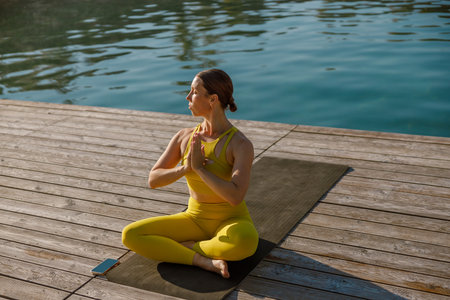 Yoga Retreat by the Water Experience Serenity in Bright Yellow Activewear During Your Sessionの写真素材