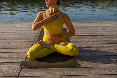Engaging in a Yoga Practice by the Tranquil Water A Journey toward Serenity and Mindfulnessの写真素材