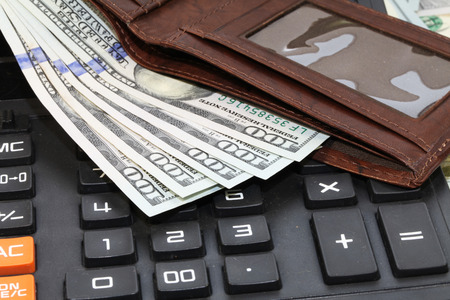 bunch of the new one hundred dollar bills wallet and a calculatorの写真素材