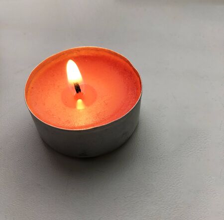 burning red candle on a white windowsillの写真素材