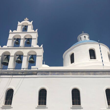 domed church with bells in Santorini, Greece. Blue dome, white walls.の写真素材