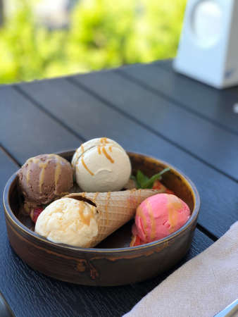 Multicolored ice cream with macaroni on plate
