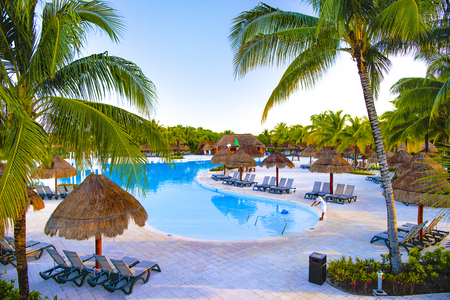 Swimming pool, palm umbrellas, sunbeds in a tropical hotelのeditorial素材