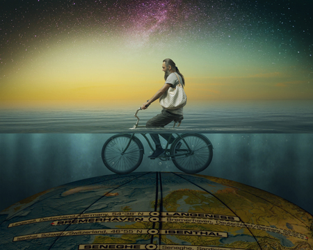 The globe is covered by the ocean. Bearded man on a bicycle under waterの写真素材